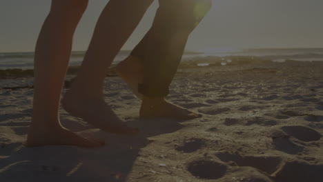 animation of light spots over caucasian couple walking on beach