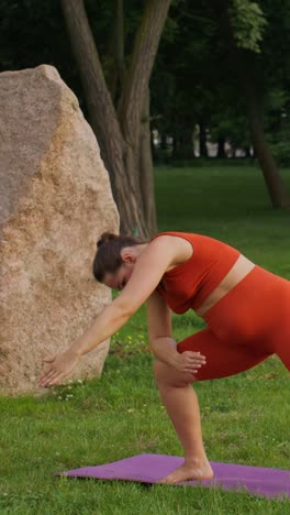 mujer practicando yoga en un parque
