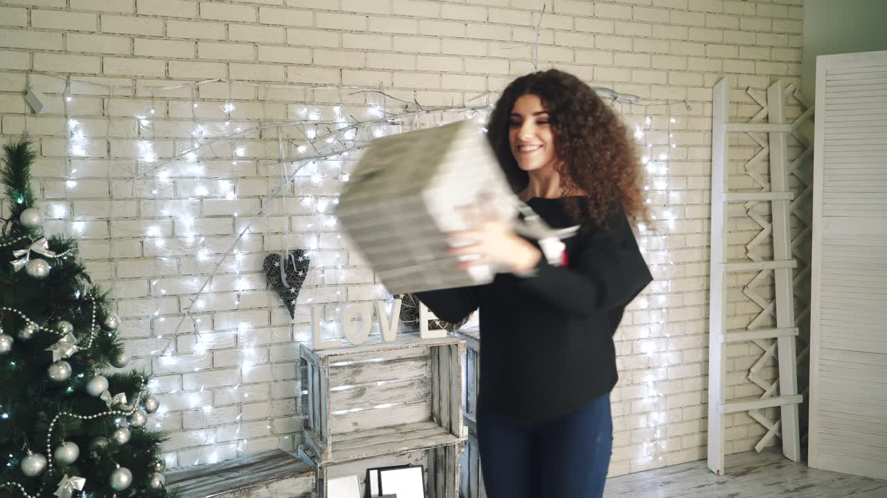 New Year presents concept. Woman opening her New Year gift boxes while lying at home