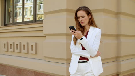 mujer de negocios molesta leyendo malas noticias en el teléfono móvil