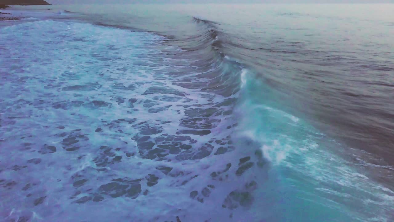 olas rompiendo en la playa rocosa del pueblo de paul do mar al atardecer