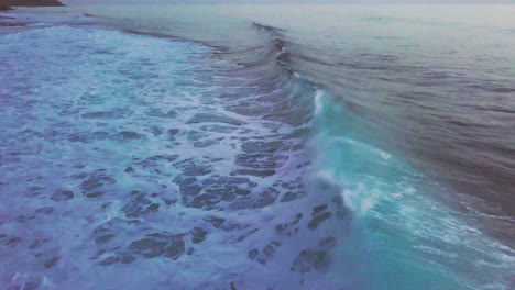 olas rompiendo en la playa rocosa del pueblo de paul do mar al atardecer
