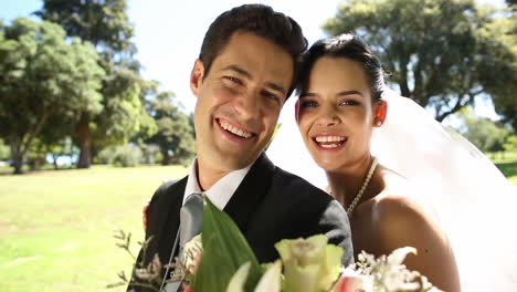 happy newlyweds riding a red scooter in the park