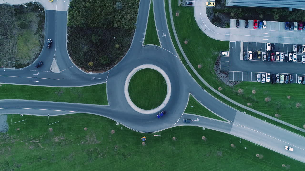 많은 자동차와 트럭이 비즈니스 파크 주변을 드나들고 있습니다.