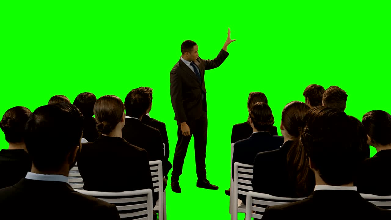 Uomo d'affari che utilizza uno schermo digitale futuristico mentre fa una presentazione ai colleghi
