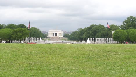 lincoln memorial temple in distance with male jogger running across shot, washington, d