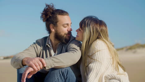 Young-Caucasian-couple-sitting-at-seashore