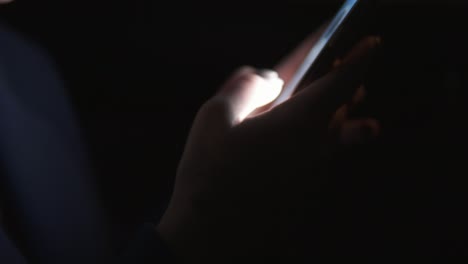 Close Up view of woman&#039;s hands texting using her smartphone. Woman riding in taxi late at night. Night live. Slow Motion shot