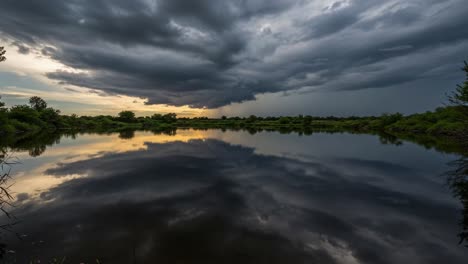 dramatic sunset and storm clouds reflecting on a calm lake
