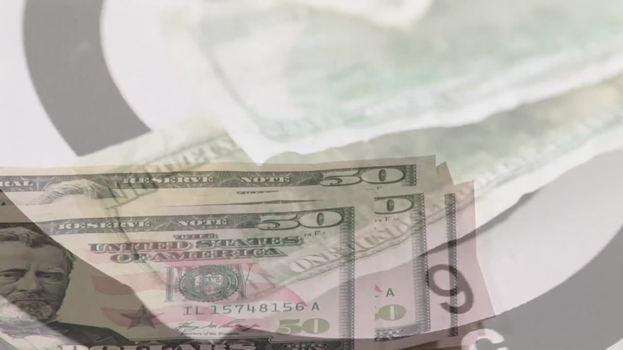Animation of bull's eye, american dollar banknotes over hand counting banknotes