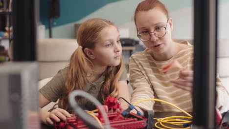 female teacher and intelligent teenage girl conducting tech project