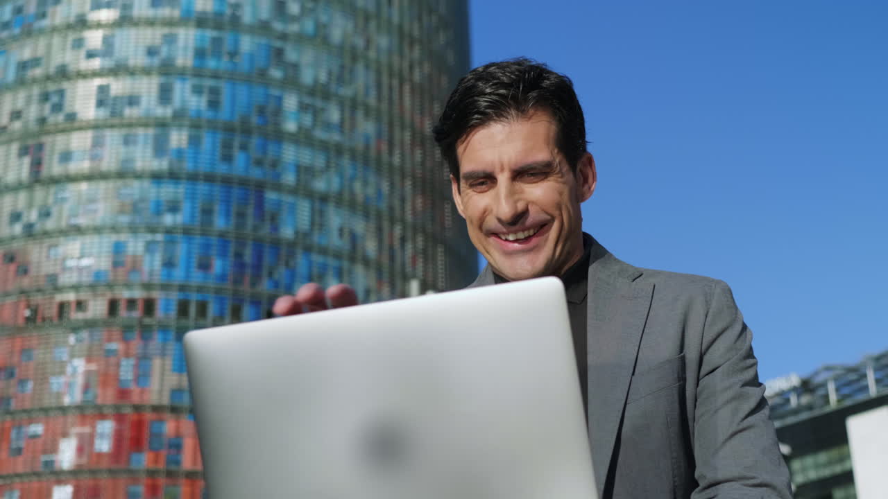 hombre de negocios leyendo buenas noticias en una computadora portátil en la calle. hombre trabajando en una computadora portátil