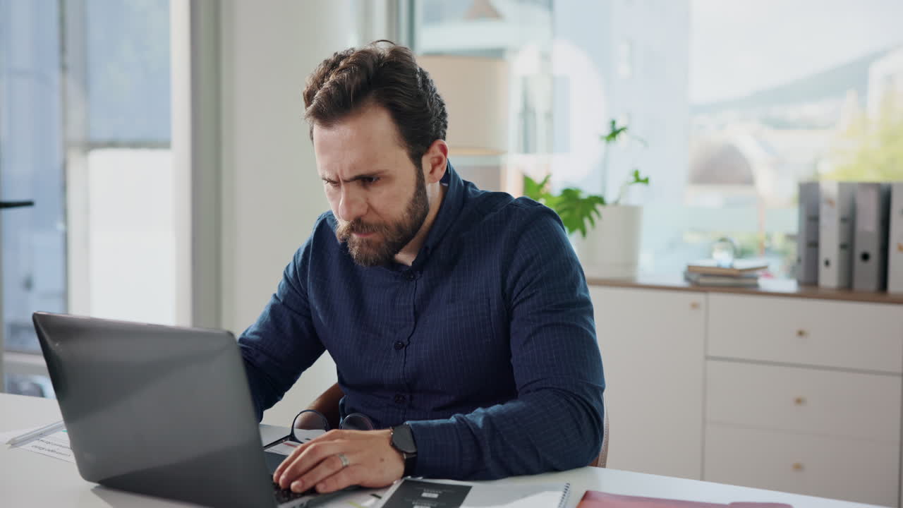 Stressed man working on laptop at home