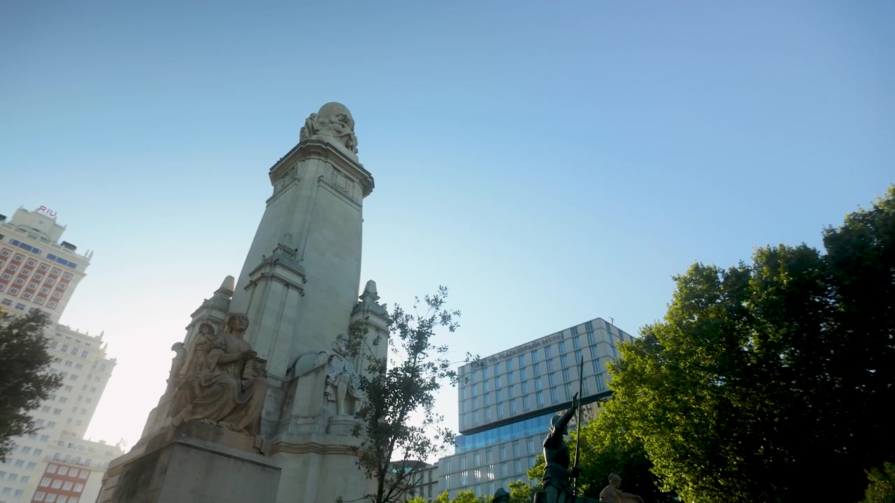 Plano contrapicado del monumento a Miguel de Cervantes y la estatua de Don Quijote en la Plaza de España, Madrid. Ideal para documentales de viajes y contenido sobre cultura española