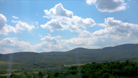 nubes de lapso de tiempo moviéndose y cielo azul sobre colinas verdes