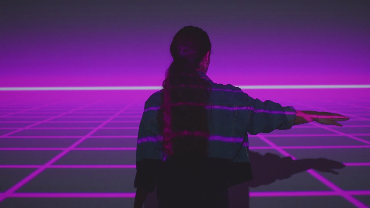 mujer visitando una exposición de arte inmersivo interactuando con la proyección de una cuadrícula en la pared