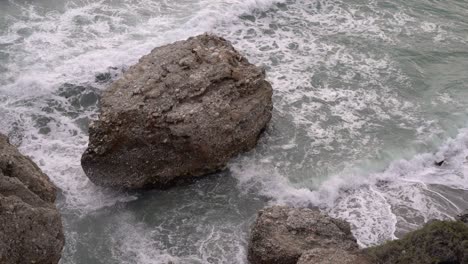 Looking-down-towards-rocks-and-ocean-in-ocean-during-rogh-sea