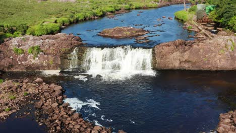 scenic aerial shot of the aasleagh falls waterfall in connemara with summer sunshine and clear river