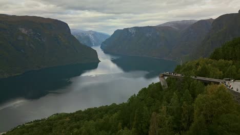 drone flies over the stegastein viewing platform in norway under cloudy skies