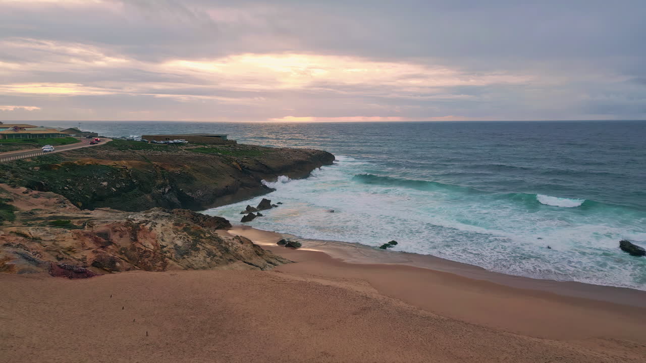 Aerial rocky sea shore washed by foamy water at evening dusk. Coastal cliffs