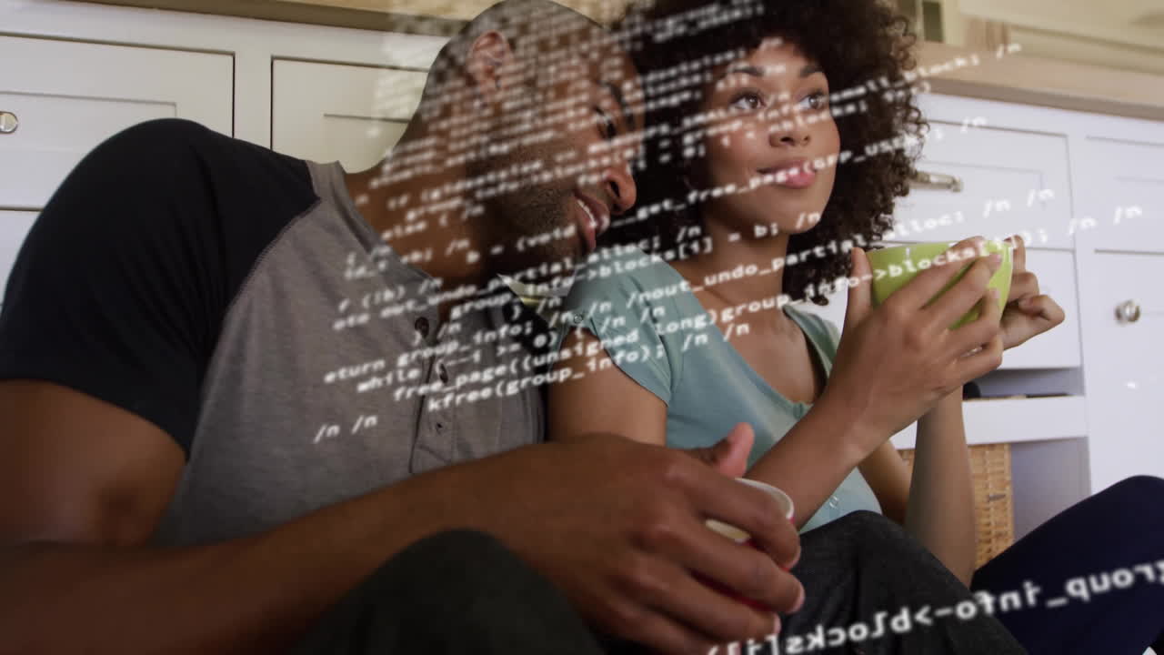 In cozy kitchen, couple drinking coffee together and watching animation on tablet