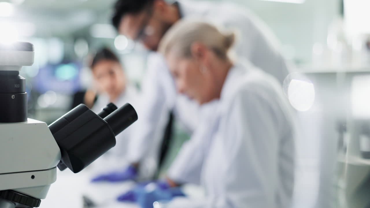 Scientists working in a laboratory with a microscope