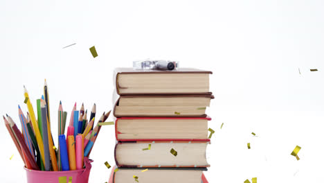 animación de confeti cayendo sobre lápices de color y pila de libros