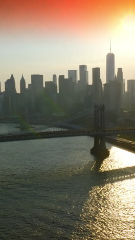 beautiful bridges of new york over east river. amazing skyscrapers against the pink sky and setting sun. vertical video