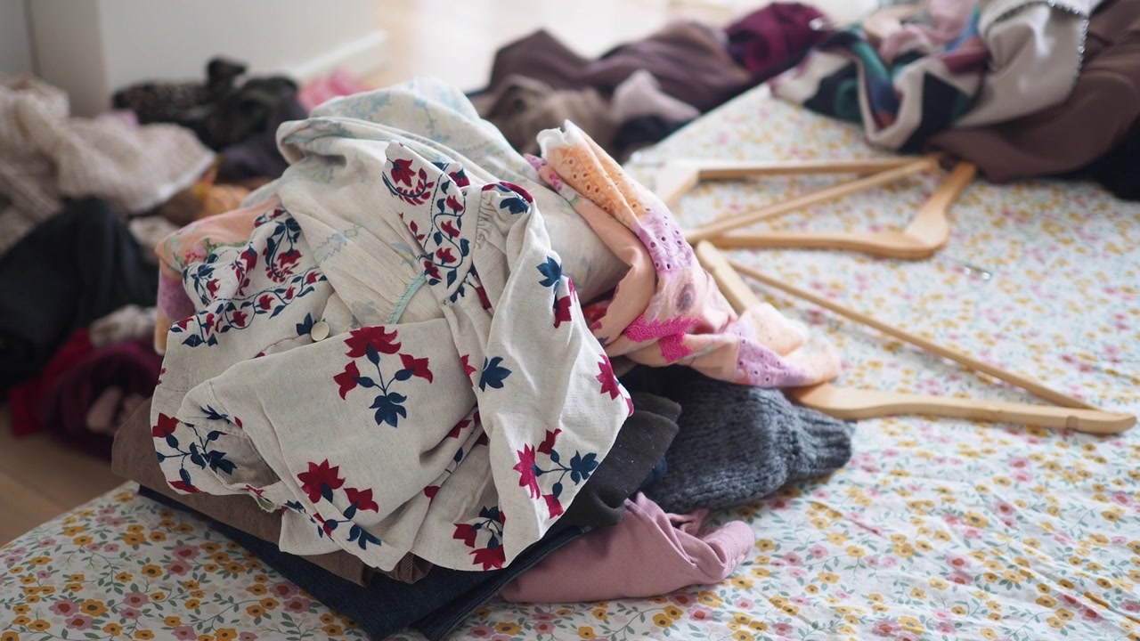 Pile of Unfolded Laundry on a Floral Bedspread