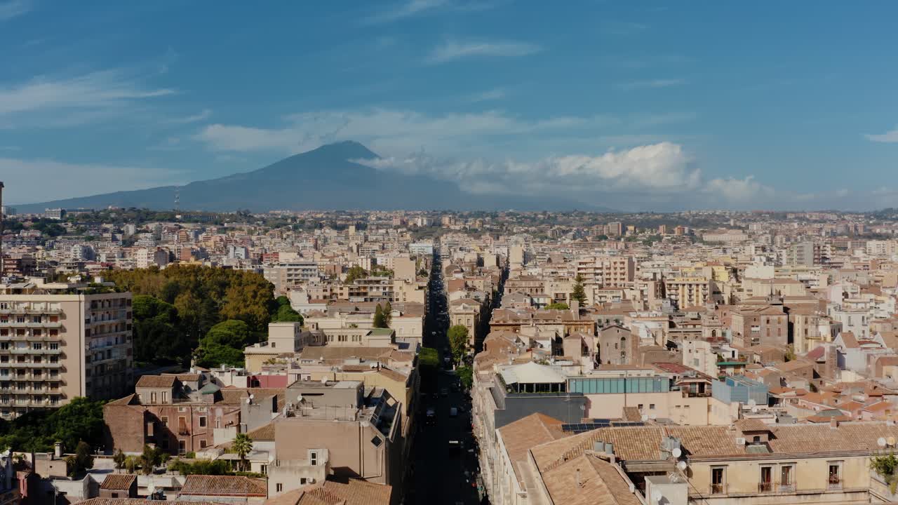 Flying straight above the main street in Catania with Europe's most active volcano Mount Etna in the background. Catania the UNESCO World Heritage. Sicily. Italy.