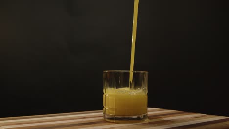 Orangensaft-Wird-In-Eine-Kurze-Schleuder-Gegossen