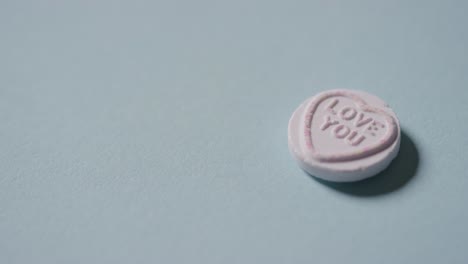낭만적인 메시지와 함께 심장 사탕을 손에 들고 파란색 배경에 당신을 사랑합니다