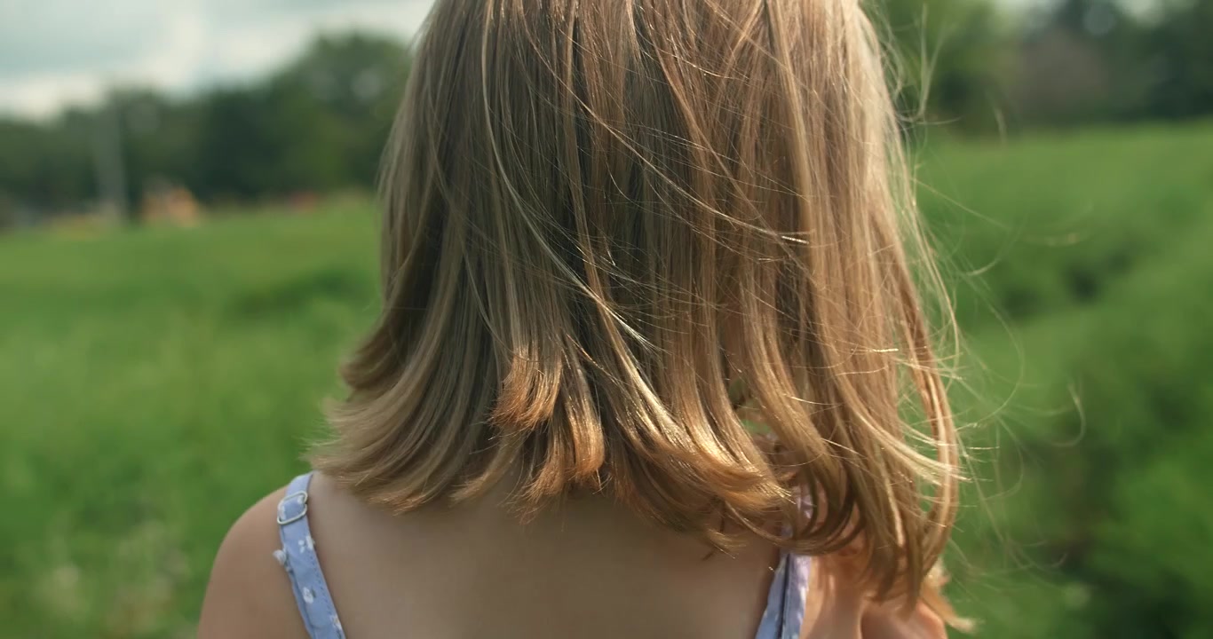 自然な環境の中で、風になびく少女の髪が動きと柔らかさを捉えている。