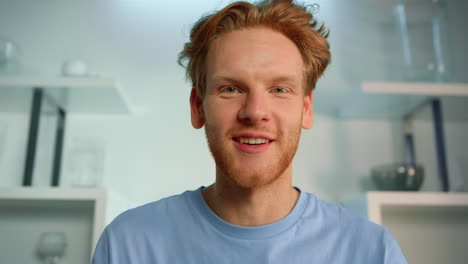 Closeup-freelancer-talk-interview-at-home-office.-Smiling-ginger-man-video-call