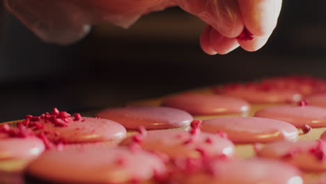 chef preparing pink macarons with raspberries