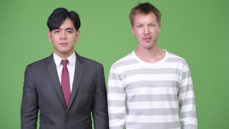 젊은 잘생긴 아시아 사업가와 젊은 스칸디나비아 사업가가 함께 일하고 있습니다.