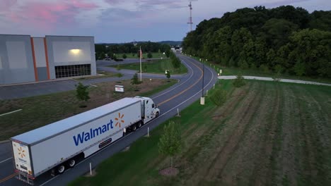 walmart truck on rural road at dawn. driving on american street, delivery for shopping mall and grocery stores in the morning. aerial tracking shot. leaving center warehouse in virginia.