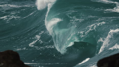 large wave breaks onto the rocks during a storm