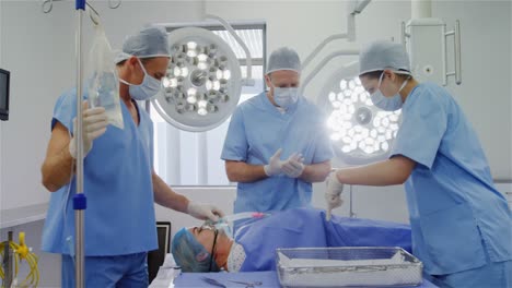 surgery team discussing while operating a patient in an operating room