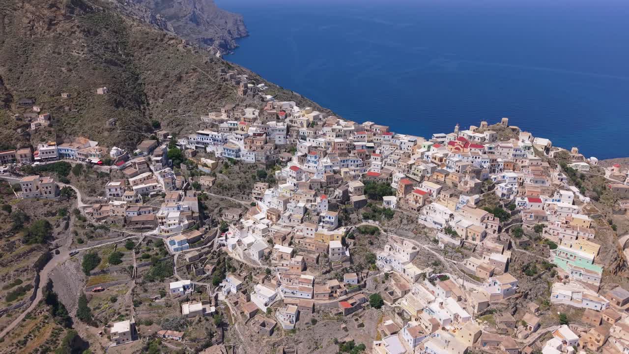 Drone orbit of the picturesque Olympos village in Karpathos Island, revealing its stunning hillside location and traditional Greek island beauty