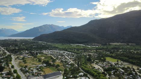 Pan-left-of-Lago-Puelo-valley-with-lake-and-Andean-mountains-in-background-surrounded-by-a-beautiful-woodland-at-golden-hour,-Chubut,-Patagonia-Argentina