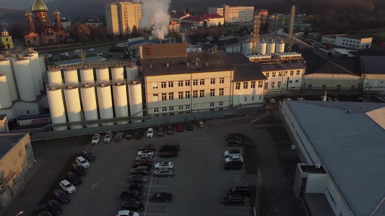 Vista aerea di un drone che sorvola il birrificio, diverse file di serbatoi