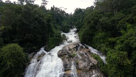 Stunning-slow-motion-drone-flight-over-top-of-waterfall-in-lush-Jungle