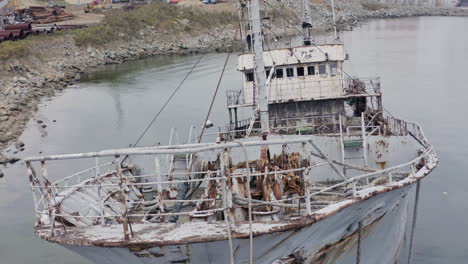 Rusty-grey-half-submerged-shipwreck-anchored-near-the-shore-on-a-cloudy-overcast-day