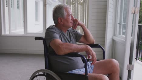 senior caucasian man on a wheelchair looking at the window