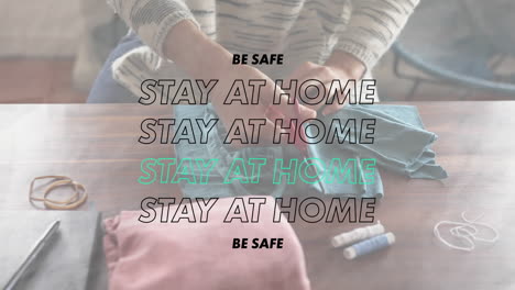 animation of words be safe stay at home over a person sewing coronavirus covid19  masks