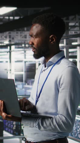 vertical video engineers in data center use laptop to monitor neural network llm visualization