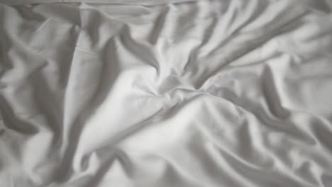 wrinkled white sheets on a bed