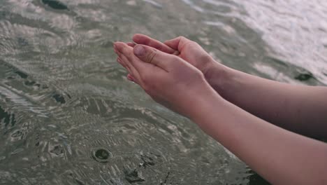 hand cupping water from the alpine lake