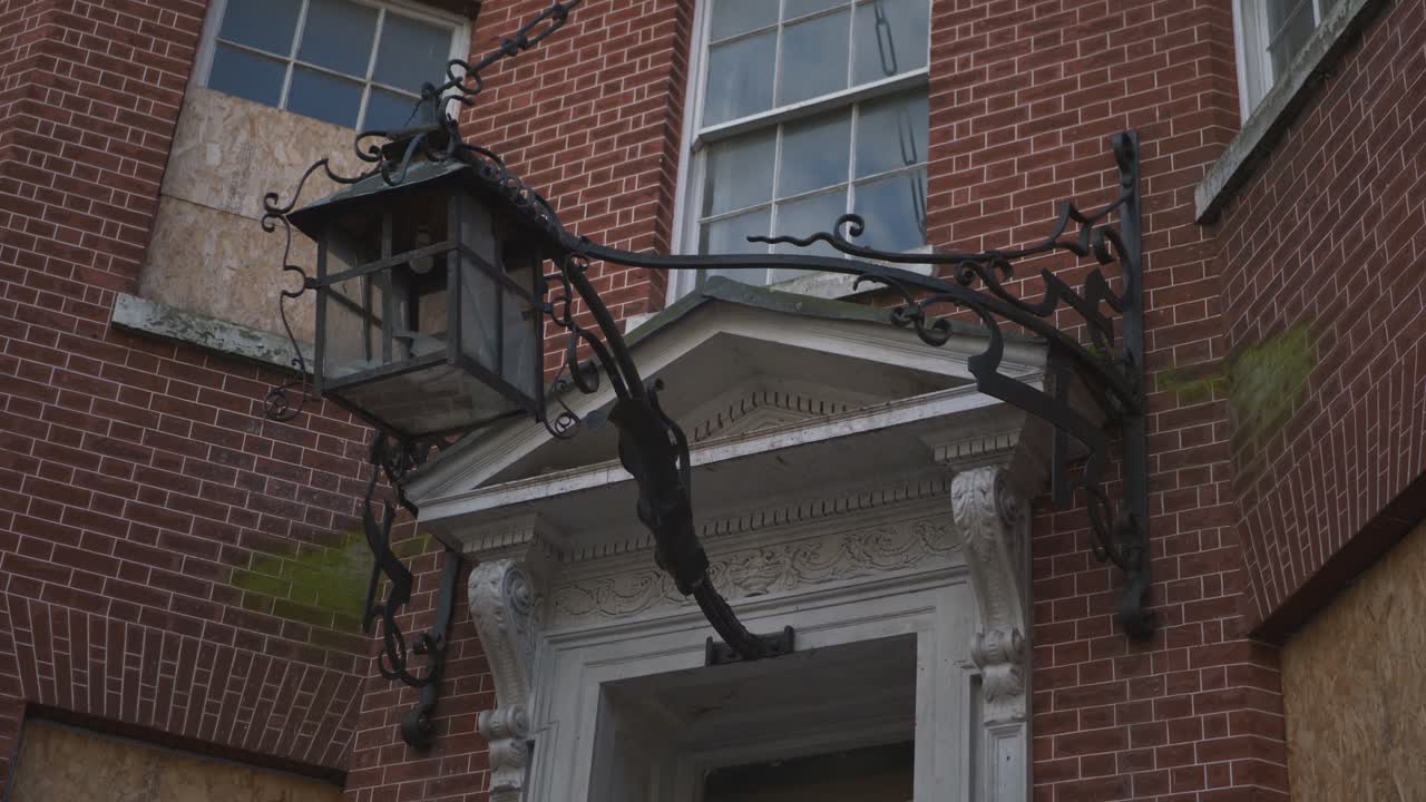 Huge Black Metal Lantern On An Abandoned Red Brick Building With Wrought Windows